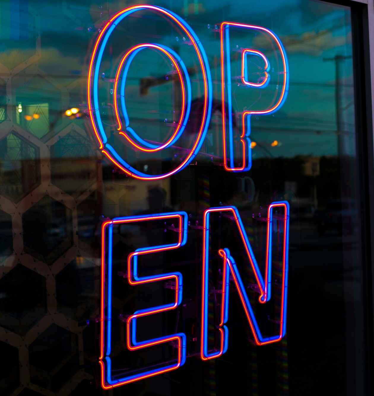 Leuchtbuchstaben in Neonschrift an einem Schaufenster mit den Buchstaben OPEN.
